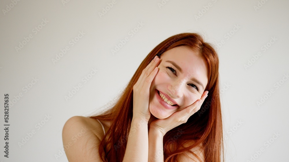 Red-haired beautiful young woman girl gently smiles