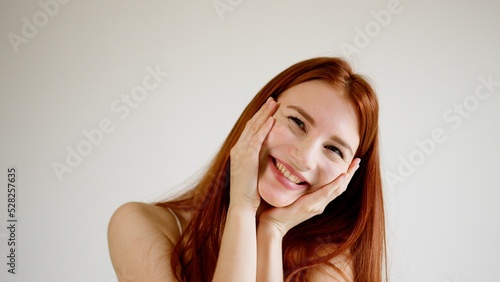 Red-haired beautiful young woman girl gently smiles