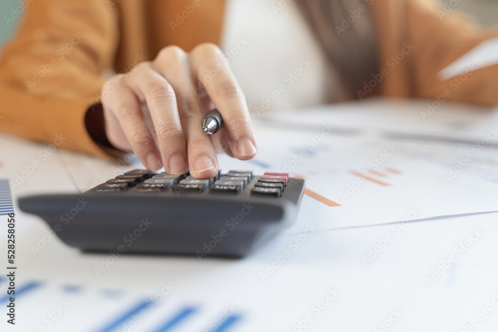 person using calculator calculating tax refund on the table person using calculator calculating tax refund on the table
