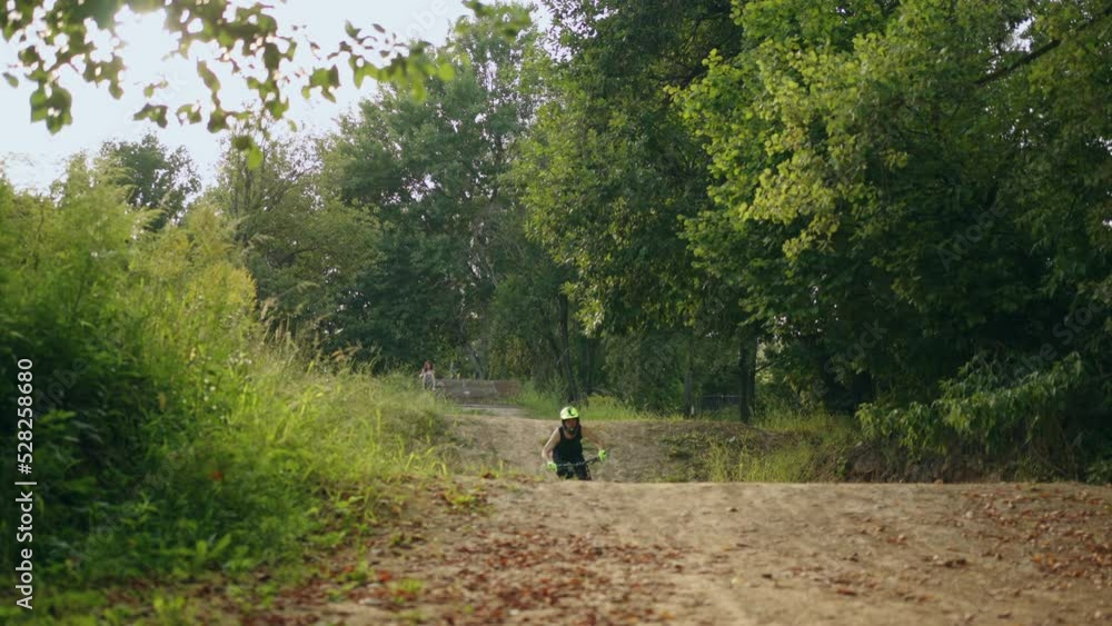 bicyclist is riding in forest, doing tricks and jumps on dirt road, MTB sportive bike for extreme bicyclist is riding in forest, doing tricks and jumps on dirt road, MTB sportive bike for extreme