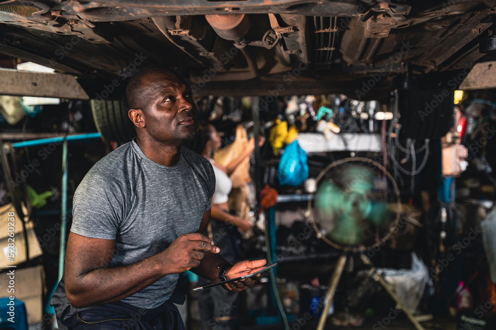 Car suspension specialists are carefully examining the broken car. Car suspension specialists are carefully examining the broken car.