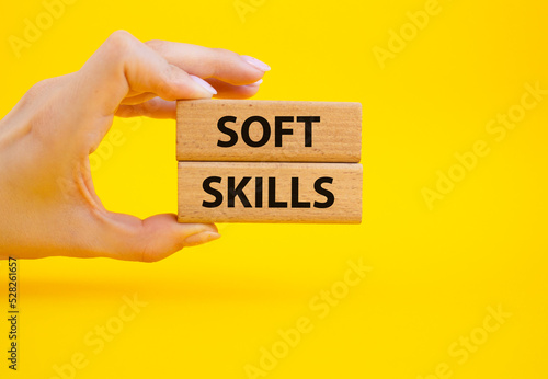 Soft skills symbol. Wooden blocks with words Soft skills. Beautiful yellow background. Businessman hand. Business and Soft skills concept. Copy space.