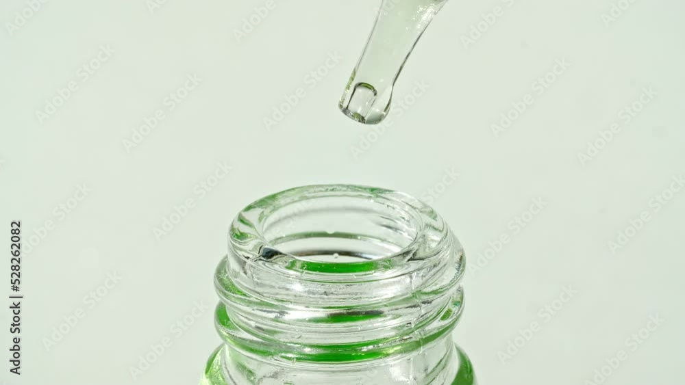 Transparent cosmetic gel fluid with bubbles in pipette dripping into the bottle. Natural Organic Cosmetics, Medicine. Production Close-up. Slow Motion. High quality 4k footage Transparent cosmetic gel fluid with bubbles in pipette dripping into the bottle. Natural Organic Cosmetics, Medicine. Production Close-up. Slow Motion. High quality 4k footage