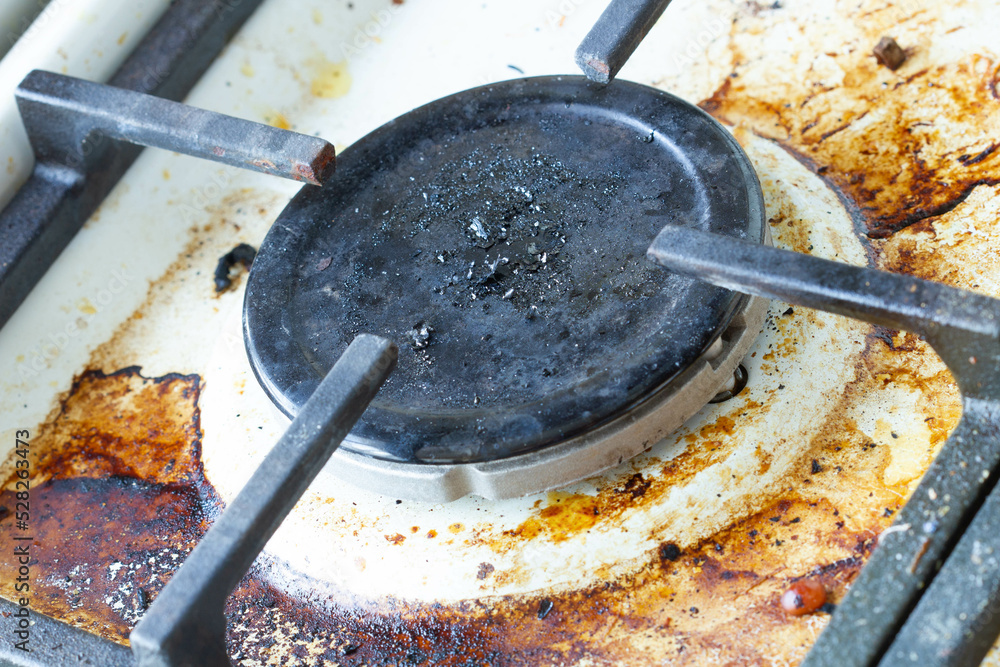 Dirty gas stove surface. Gas burner and cast iron grate of a gas oven