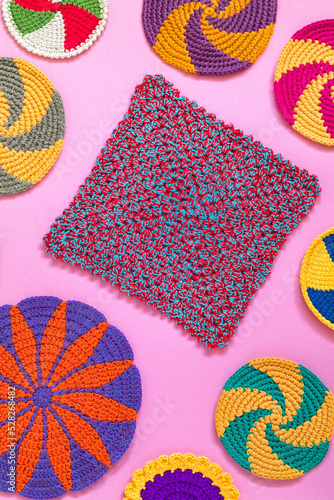 Fotografi Bright colorful crochet dishcloth and cup coaster on a pink background