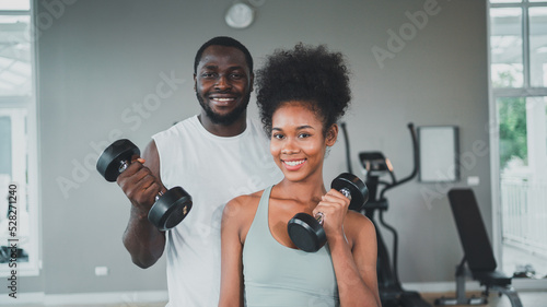 Women do weight training with male coaches.Exercise for different musclesA beautiful smiling woman is satisfied with her body.indoor sports.,