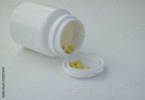 bottle pills and medicine capsule on table, drugs and tablets boxes in background