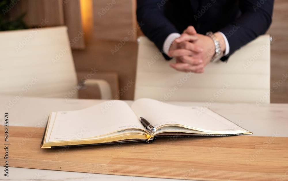 young businessman in a dark blue suit working in the office, writting in a diary young businessman in a dark blue suit working in the office, writting in a diary