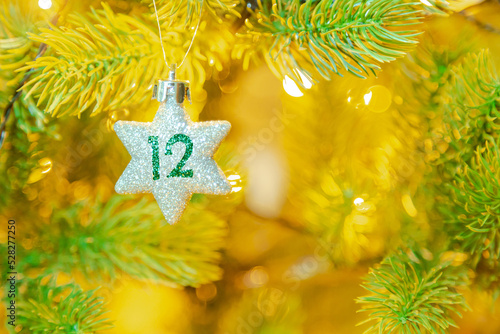 Obraz na płótnie Weihnachtsschmuck (Stern) am Baum mit einer Zahl (12) vom Weihnachtskalender w salonie