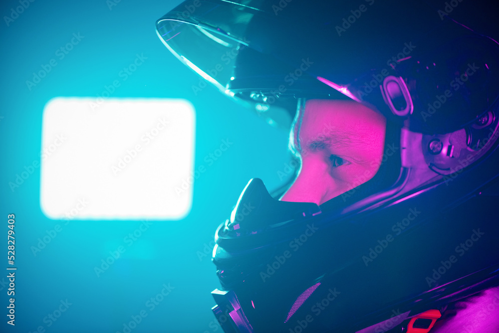 A portrait of motorbiker in the helmet in the neon lights.