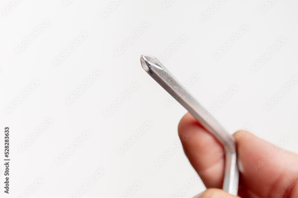 Human hand holding a Phillips screwdriver on white background with copy space Human hand holding a Phillips screwdriver on white background with copy space