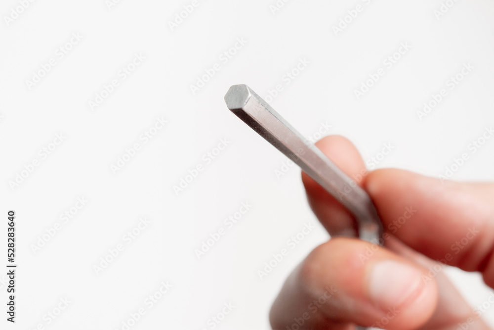 Human hand holding a Allen Key on white background with copy space Human hand holding a Allen Key on white background with copy space