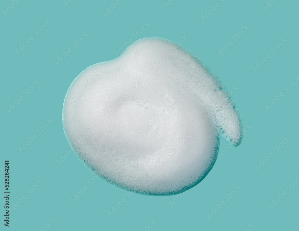 Fototapeta premium Foam lather texture background. White cleanser gel, shaving foam, shampoo bubbles on blue.