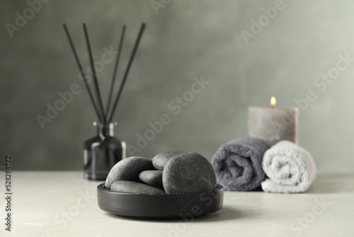 Spa stones in black tray on light marble table