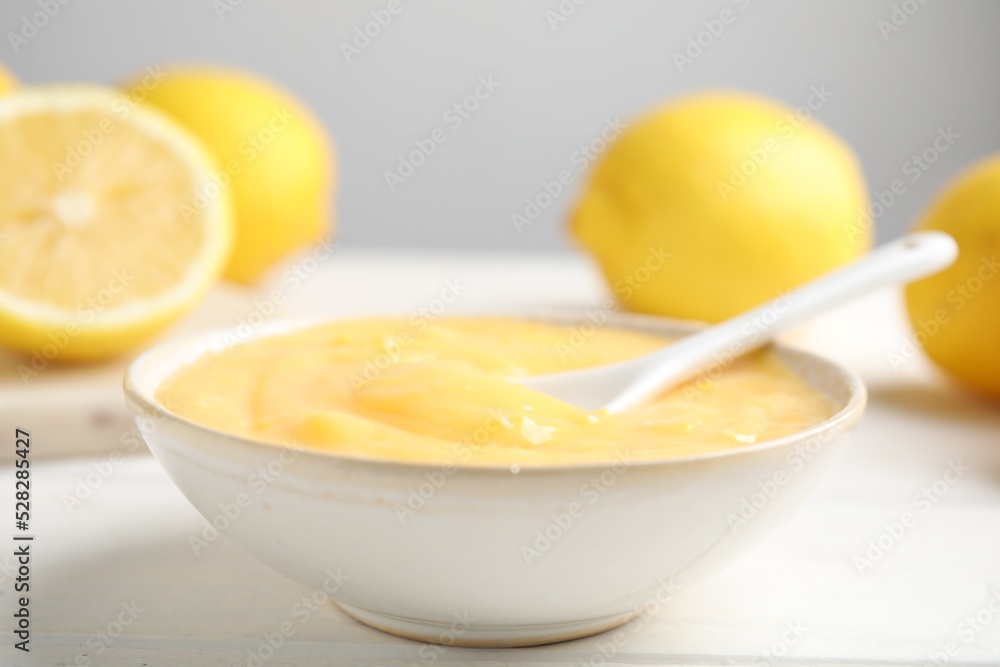 Delicious lemon curd in bowl on white wooden table, closeup Delicious lemon curd in bowl on white wooden table, closeup