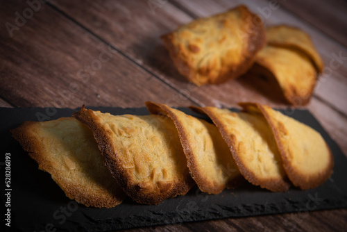 French delicacy pastry tuile with almond on wood background, High quality photo