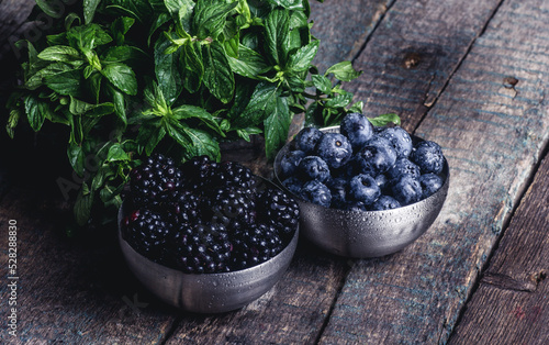 Obraz na płótnie Fresh tasty berries. Blueberries and blackberries on a wooden table w salonie