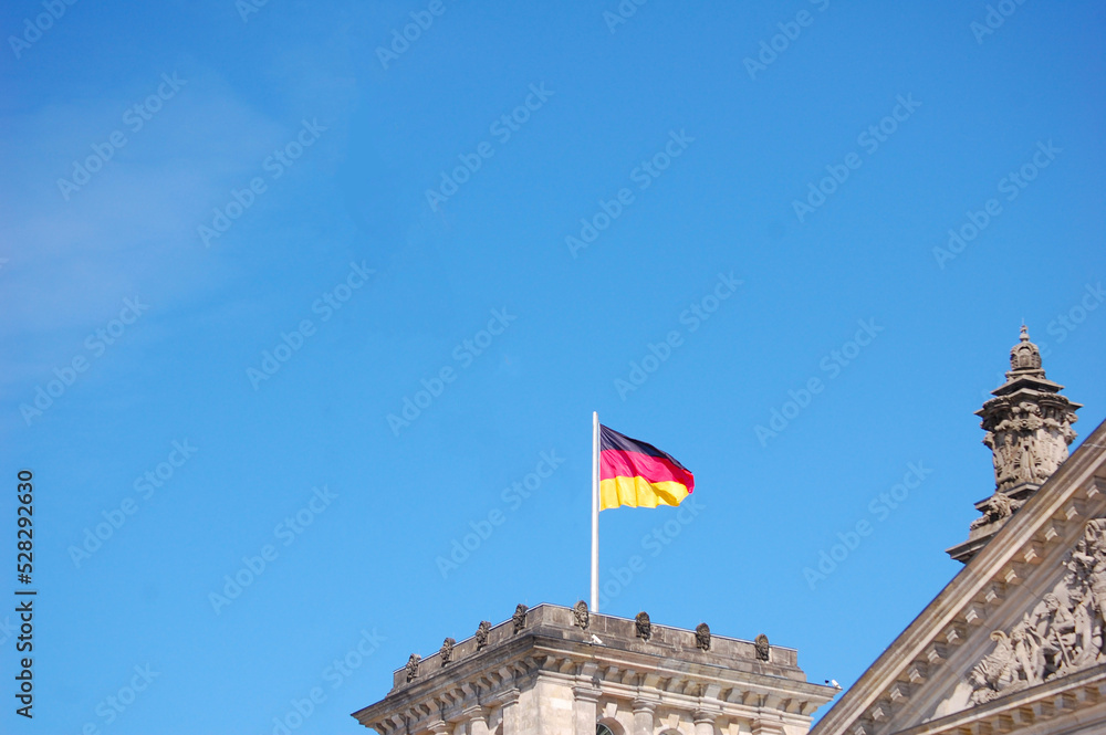 Reichstag building in Germany with German flag waving