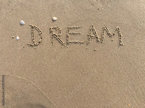 on the beach is carved with letters in the smooth sand the writing Dream © Marcus