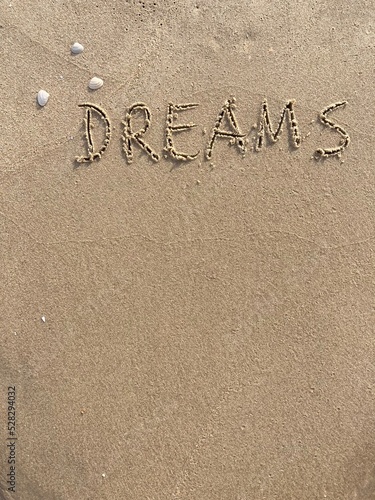 on the beach is carved with letters in the smooth sand the writing Dreams © Marcus