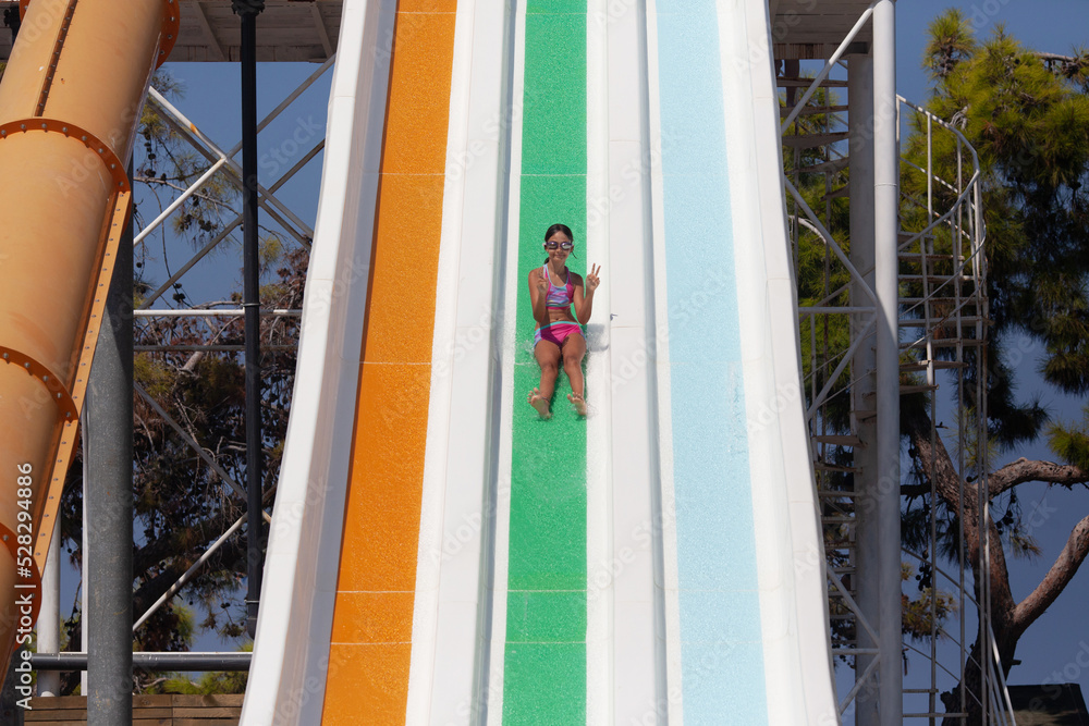 Fototapeta premium Girl 10 years old on a water slide