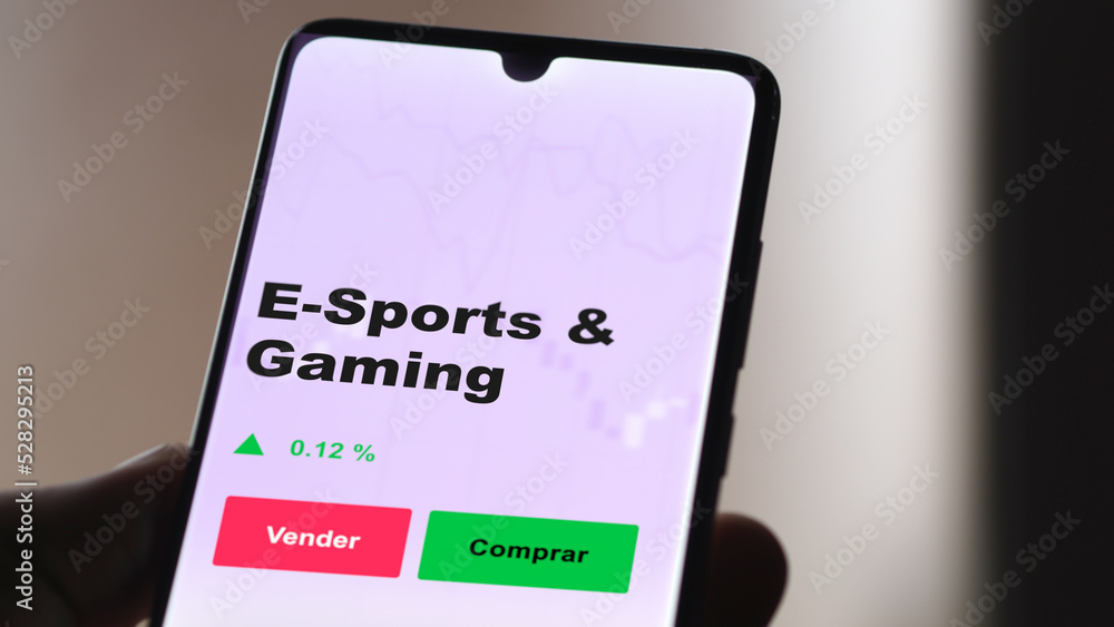 Un inversor está analizando el e-sports & gaming etf fondo en pantalla. Un teléfono muestra los precios del ETF para invertir. Texto en español.