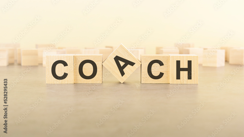five wooden blocks with the letters COACH on the surface table five wooden blocks with the letters COACH on the surface table