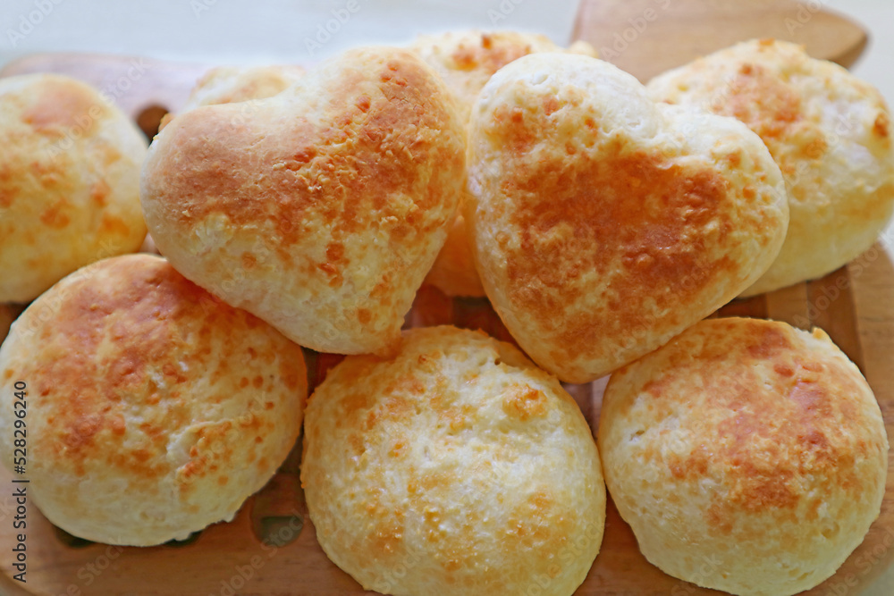 Pile of Freshly Baked Homemade Pao de Queijo or Brazilian Cheese Breads with a Pair of the Heart Shaped on Top