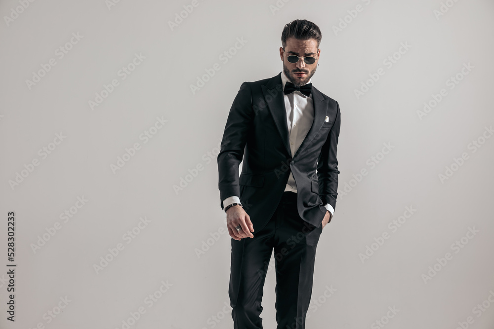 groom in black tuxedo with hand in pocket looking down groom in black tuxedo with hand in pocket looking down