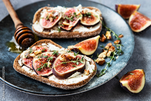 Toasts with cream cheese, figs and honey on the table
