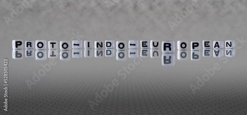 proto indo european word or concept represented by black and white letter cubes on a grey horizon background stretching to infinity photo