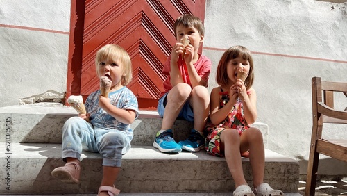 Wallpaper Mural Three siblings sitting and eating ice cream on the stairs Torontodigital.ca