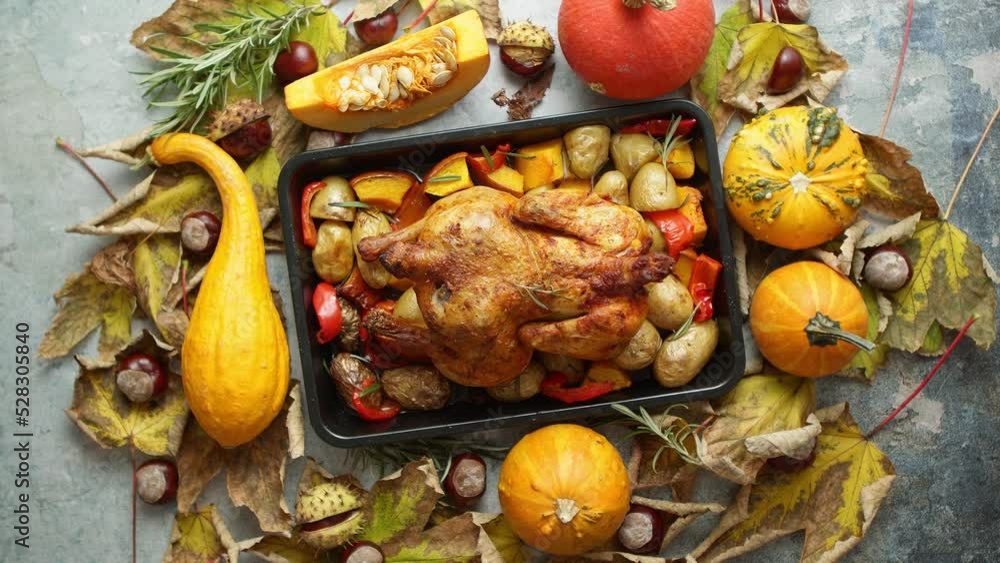 Roasted turkey or chicken with thyme served on black baking dish with potatoes, pumpkins Roasted turkey or chicken with thyme served on black baking dish with potatoes, pumpkins