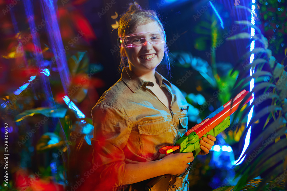 Obraz premium smiling modern child with toy gun in virtual reality