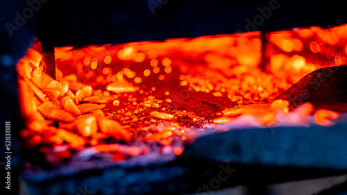 Hot coals in the grill, background, glowing coals in the background, mid view