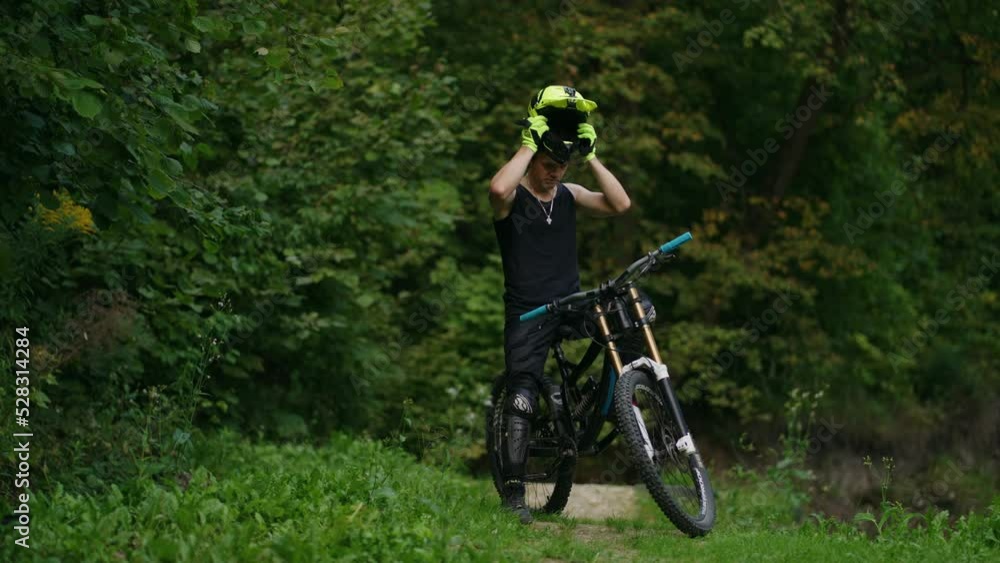 cyclist is wearing helmet, preparing to race or training in forest, ride MTB bike, extreme sport cyclist is wearing helmet, preparing to race or training in forest, ride MTB bike, extreme sport