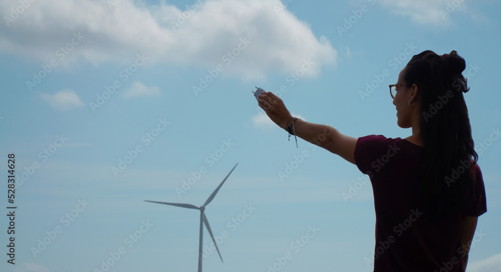 Sustainable energy production, clean energy. Woman with a plug. Sustainable energy production, clean energy. Woman with a plug.