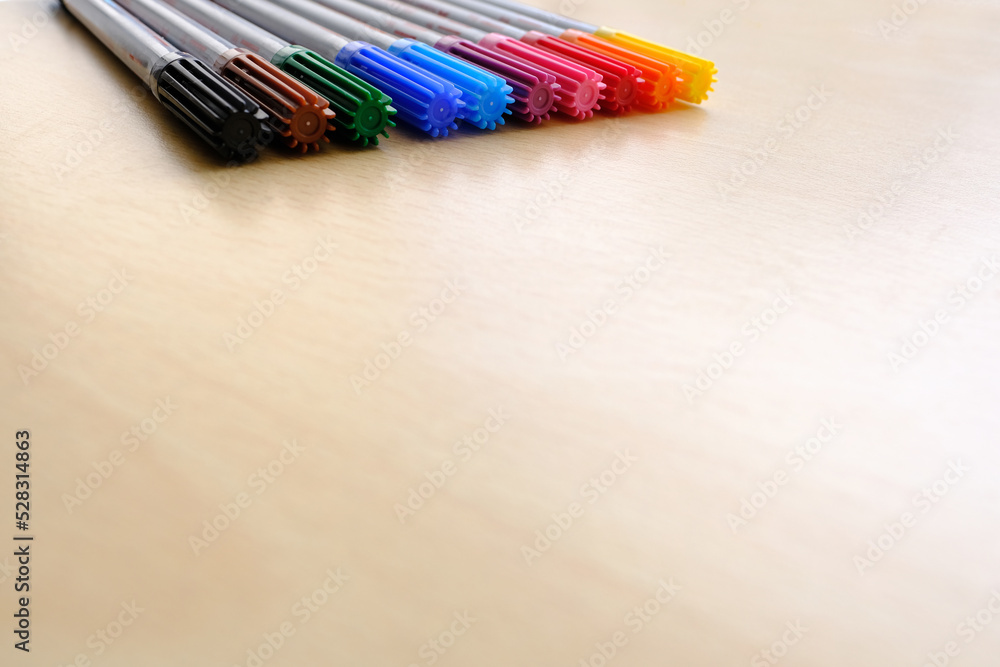 Fototapeta premium school background, colored felt-tip pens lie on a light table, close-up, the concept of student writing supplies, back to school