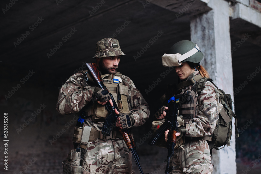 Fully equipped and armed ukrainian soldiers checking their equipment while taking a break.. Fully equipped and armed ukrainian soldiers checking their equipment while taking a break..