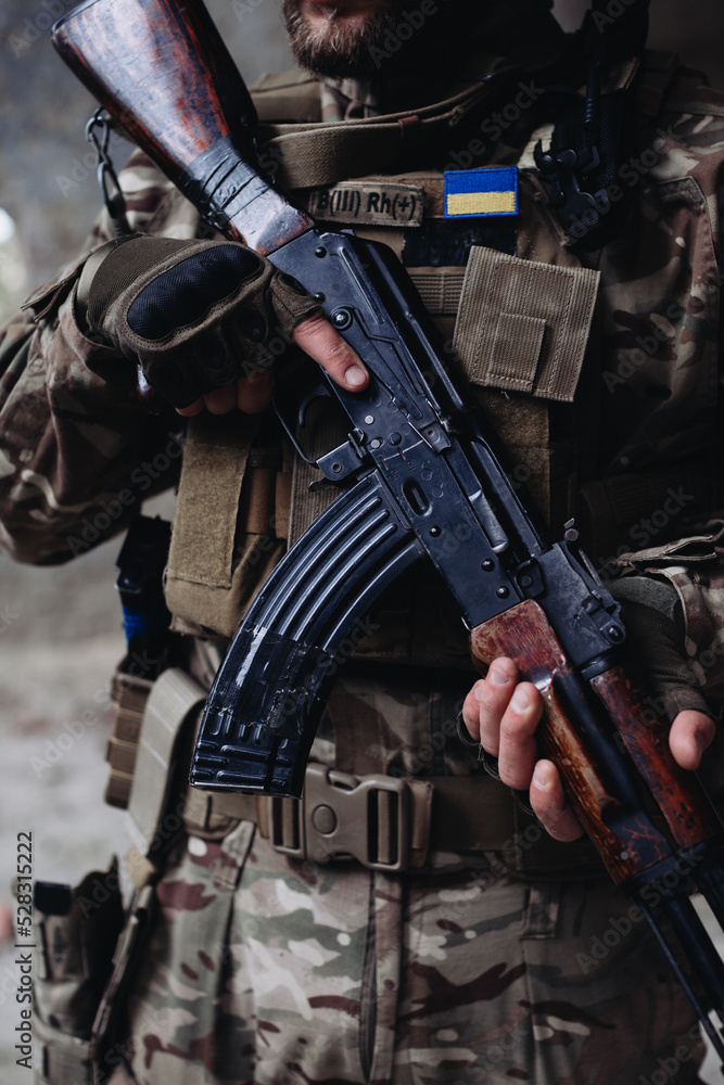 A soldier is holding an assault rifle, close-up. A soldier is holding an assault rifle, close-up.
