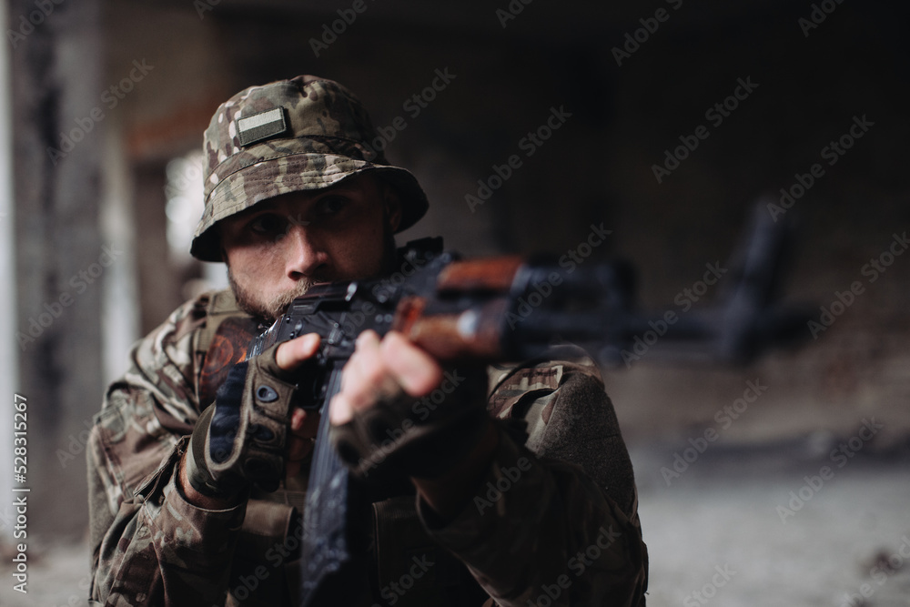 The Ukrainian military is defending its positions..Soldier in war, with weapons in his hands, aiming at the enemy The Ukrainian military is defending its positions..Soldier in war, with weapons in his hands, aiming at the enemy