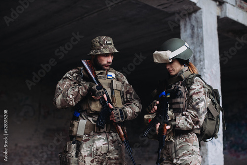 Fully equipped and armed ukrainian soldiers checking their equipment while taking a break..