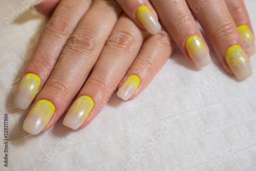 Manicured hands of a beautiful woman. Delicate nails with colorful manicure in beauty salon