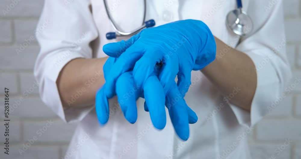 Doctor takes medical gloves. A doctor show her blue protective gloves on her hands. Doctor takes medical gloves. A doctor show her blue protective gloves on her hands.