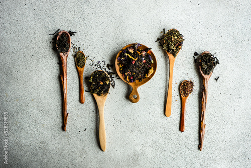 Overhead view of wooden spoons with assorted teas lined up on a table