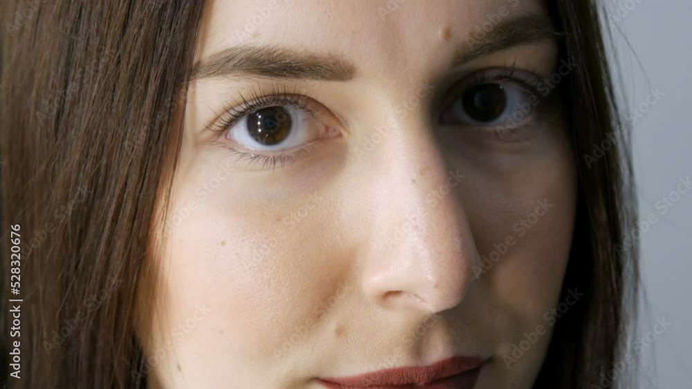 The face of a young girl before a modern eyelash lamination procedure in a professional beauty salon before the eyelash curling procedure. Portrait of a woman without makeup with dark lipstick The face of a young girl before a modern eyelash lamination procedure in a professional beauty salon before the eyelash curling procedure. Portrait of a woman without makeup with dark lipstick