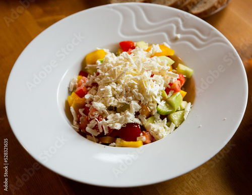 Shopska salad - dish of Balkan cuisine. Cucumbers, tomatoes, bell peppers and brynza (salted sheep cheese)