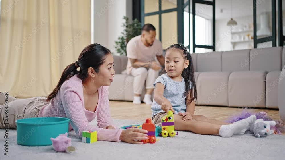 Father comes to mother and daughter to play with constructor Father comes to mother and daughter to play with constructor