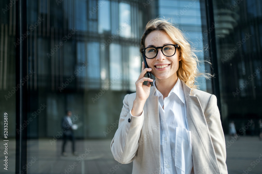 A woman is talking on the phone with a partner. Glasses on his face, goes to work in a new office. A woman is talking on the phone with a partner. Glasses on his face, goes to work in a new office.