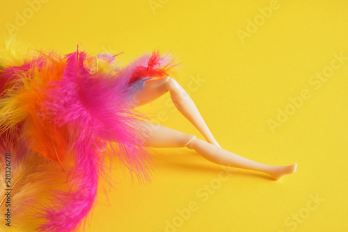 Legs of a plastic doll with feather feathers